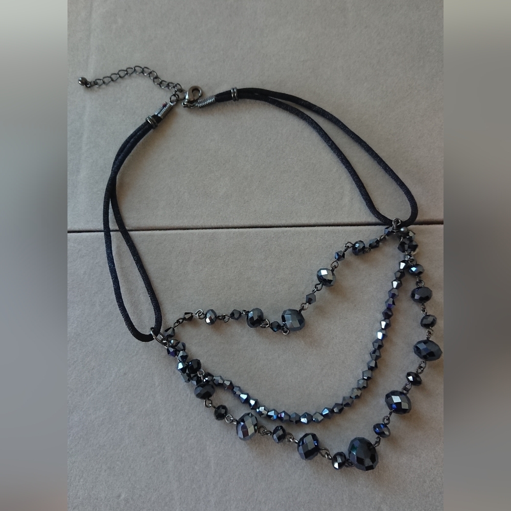Elegant three-strand statement necklace featuring faceted black glass bead